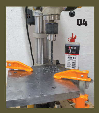 04. The various holes are drilled in the baseplate, again using a drill press and cutting fluid. The author suggests draping an old towel or drop cloth under the drill press table because the oily steel shavings will fly everywhere. Be sure to wear approv