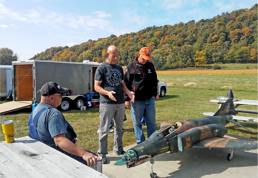 While at the Bill Beach Jet Classic event, held by the Rosewood RC Flyers in Rosewood IN, in October 2022, Ben Burden (center) discussed with Gerry Bowling (L) and Dave Brawley the proper gloss clearcoat for a nicely weathered F4 Phantom.