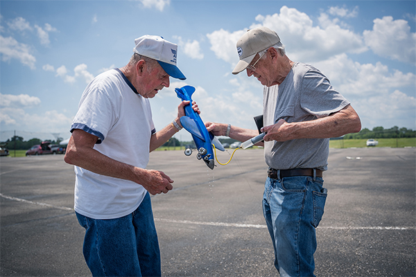 Henry Nelson and Carl Dodge work to refuel before a flight in CL Speed.