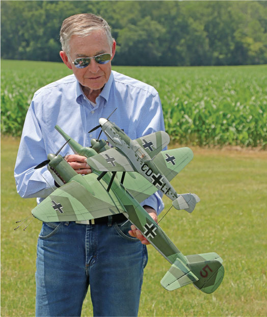 Keith Trostle is shown with his German Mistel composite aircraft, which is a Junkers Ju 88 on the bottom and a Messerschmitt Bf 109 on the top. It has three-line throttle control for all three motors. 