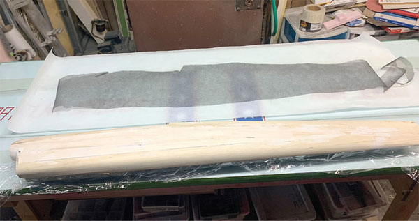 The balsa wood skin is shown after being formed over the mold. The author put plastic wrap between the mold and balsa skin. The carbon-fiber veil is ready for resin. 