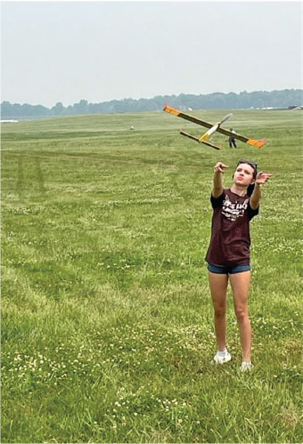 Sarah Dalecki launches her P-30 Rubber model on a test flight. Tip plates provide roll stability. 