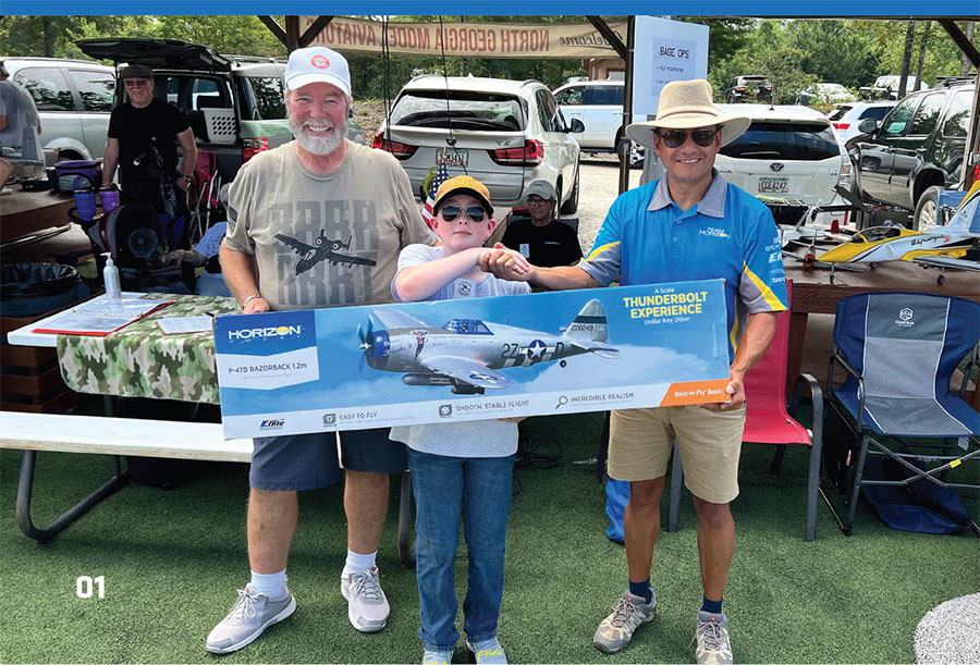 TJ Klise and Pedro Sanchez present Caleb Schneider with a P-47D from Horizon Hobby. 