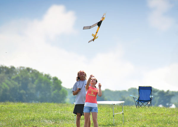 Haley Mattson, the Junior Mulvihill winner, launches her rubber-powered model while Bill Reuter times her flight.