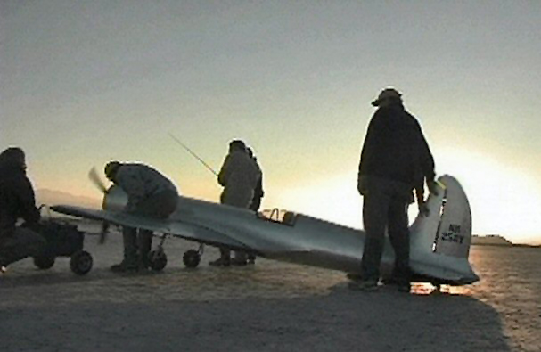 On the flightline (L-R), Jason Somes, Darrel Hoffman, Adam Gelbart, Joe Bock, and John Keefe prepare to start the H-1 race airplane. Aero Telemetry crew starts engine for first flight while sun sets fast in the west.