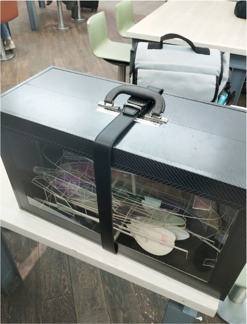 The author’s model box was wrapped with a belt around it after it was damaged by an airport security scanner. 