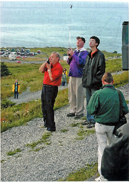 Cyrus Abdollahi (in black jacket) and Maynard watch as Joe Foster steers TAM 5 during climbout on August 9, 2003. TAM 5 was programmed to avoid parking lot in background for safety’s sake. Foster photo.