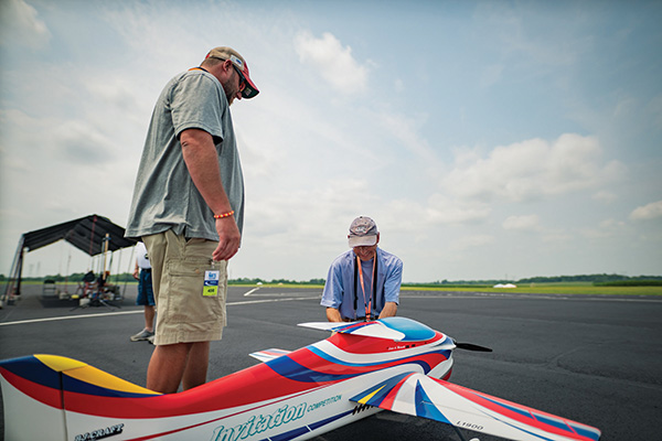 chuck edwards watches louis matustik prepare his airplane to compete in the rc aerobatics